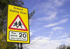 Traffic sign warning of school safety zone where 20mph applies when lights are flashing
